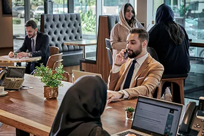 Professionals work and communicate efficiently in a sophisticated Servcorp coworking space in Saudi Arabia, designed for productivity and comfort.