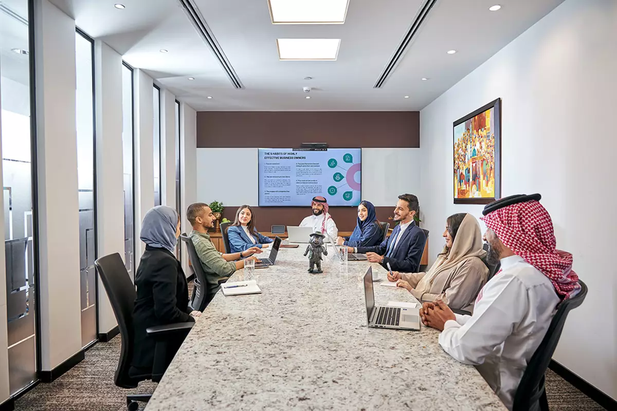 A diverse team engages in a high-level meeting inside a Servcorp boardroom in Saudi Arabia, designed for executive collaboration and professionalism.