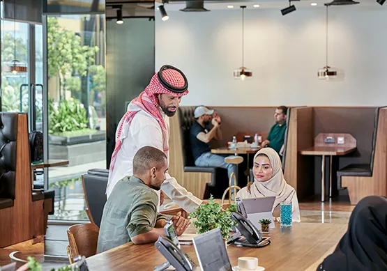 Professionals collaborate in a vibrant coworking space at Servcorp Al Faisaliah Center, blending Saudi elegance with world-class business amenities.